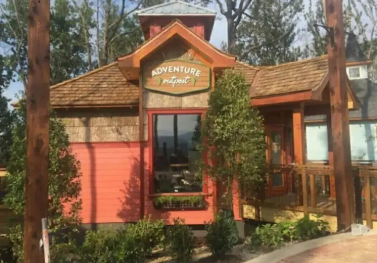 The Adventure Outpost's colorful facade and welcoming sign set the stage for outdoor excursions and guided tours, inviting visitors to discover local trails, activities, and community events.